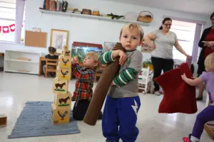 A child working with Montessori sensorial materials, such as color tablets to explore shades.