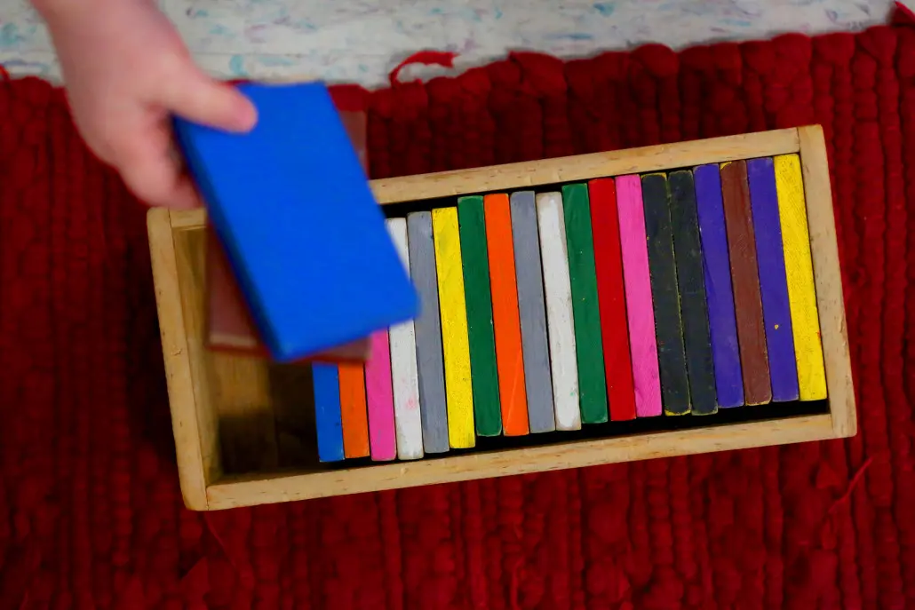 A Montessori toddler shelf, carefully organized with hands-on learning materials accessible to children.