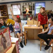 A Montessori teacher guiding a child in a self-directed learning activity, promoting independence.