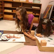 A Montessori toddler shelf, carefully organized with hands-on learning materials accessible to children.