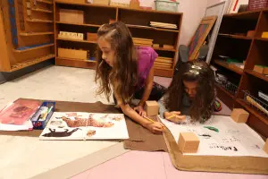 A Montessori toddler shelf, carefully organized with hands-on learning materials accessible to children.